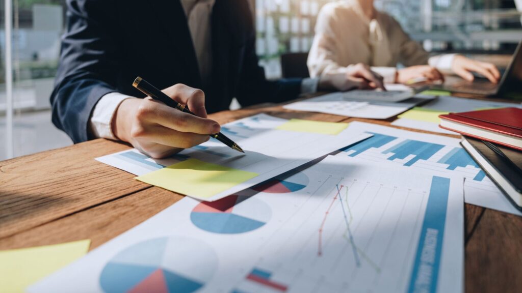 Strategische Führung: der Kompass, um Unternehmen in die Zukunft zu lenken 2 Manager führt ein Team mit einem symbolischen Kompass als Metapher für strategische Führung